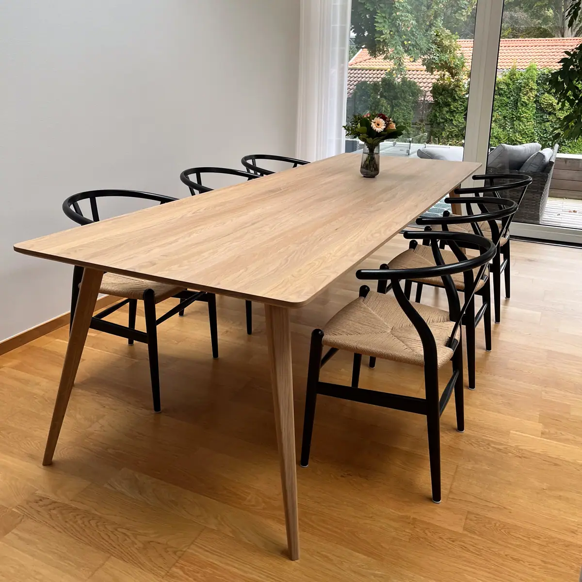 Matbord i massiv ek med stolar i ljust rum